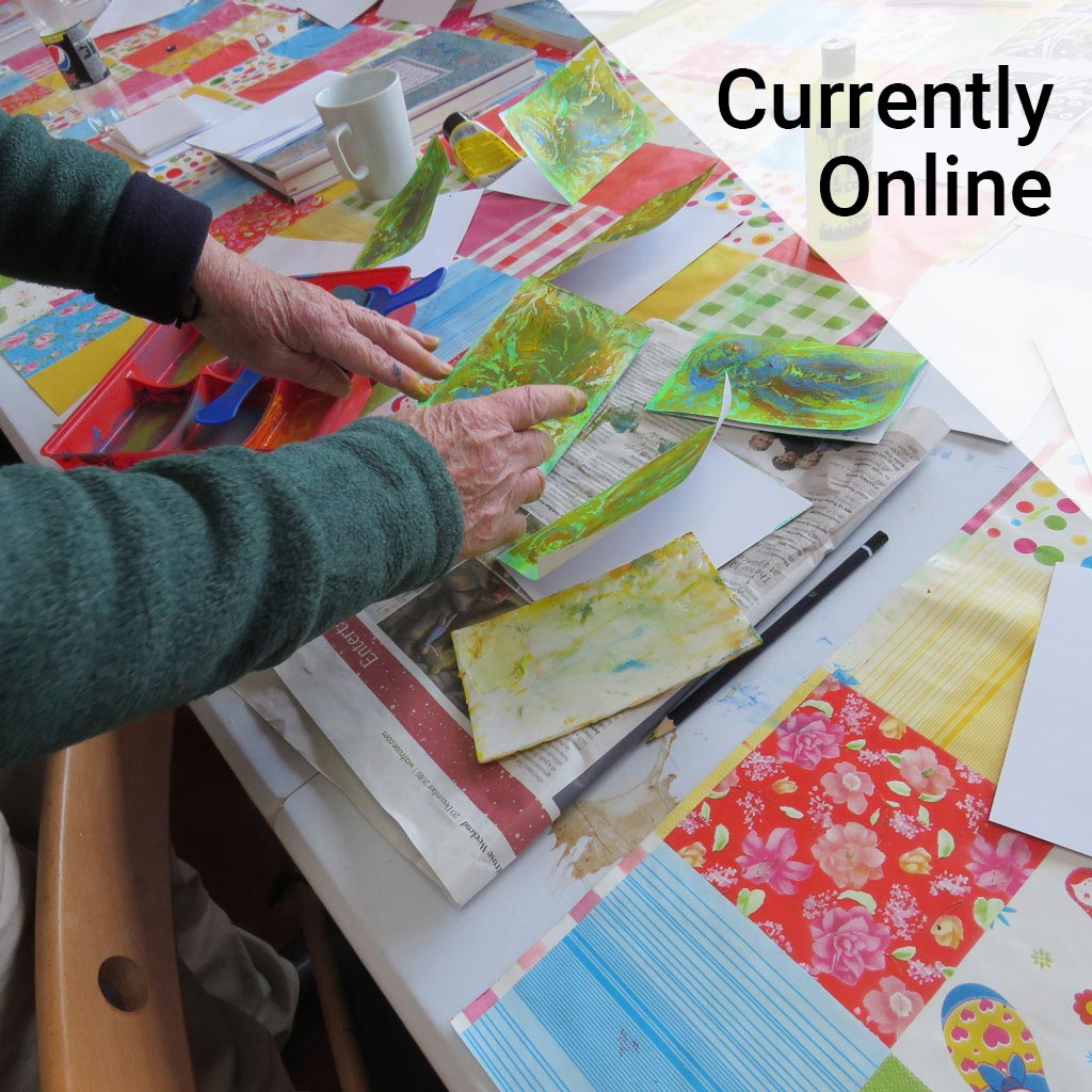 Close up of two hands with brightly coloured art work.