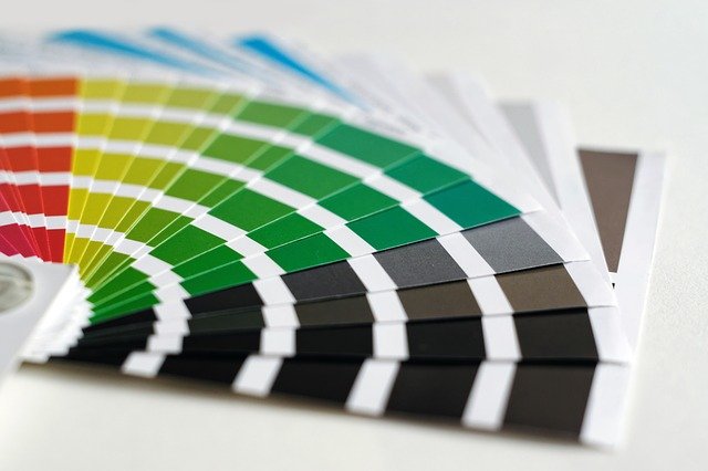 A fanned out selection of coloured paint charts.